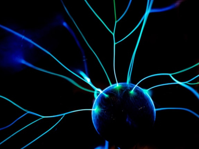 A photo of a ball with blue and green lights sparking off it to illustrate the role brain science plays in storytelling.